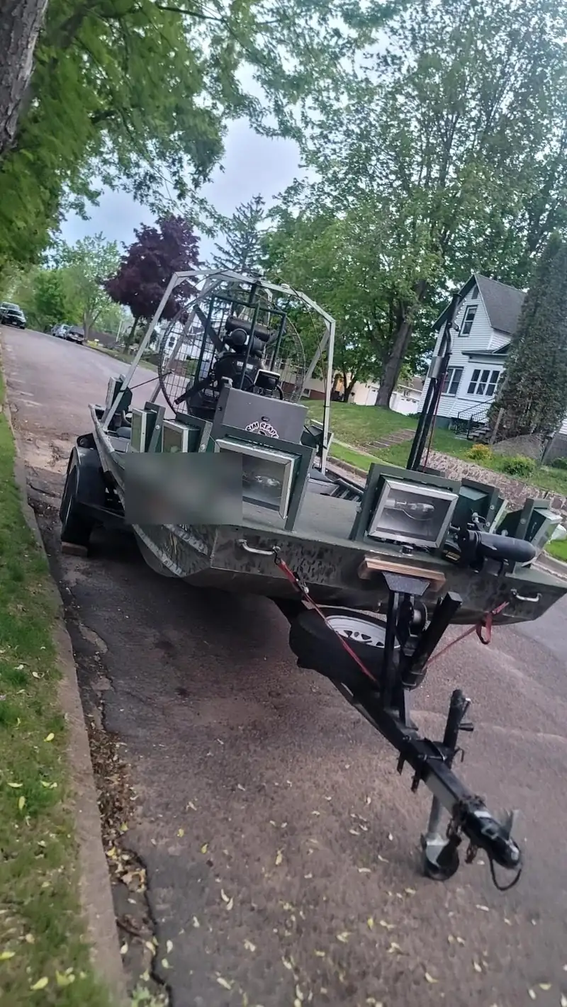 An airboat on a trailer. The registration number is covered.