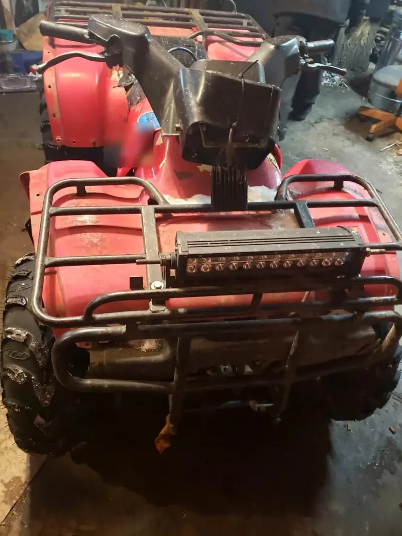 The front of a red ATV with a light bar.