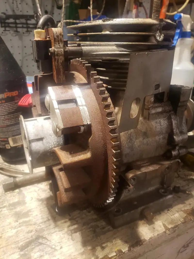 An engine opened up on the bench, gear and clutch visible.