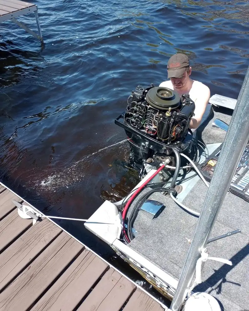 An outboard with the cover off at the dock.