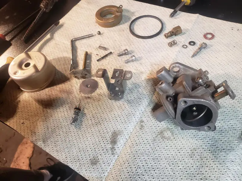 A carburetor taken apart on a shop towel.