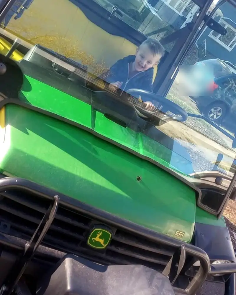 A green John Deere Gator in the shop.