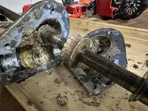 An open gearcase with metal shavings in the oil.