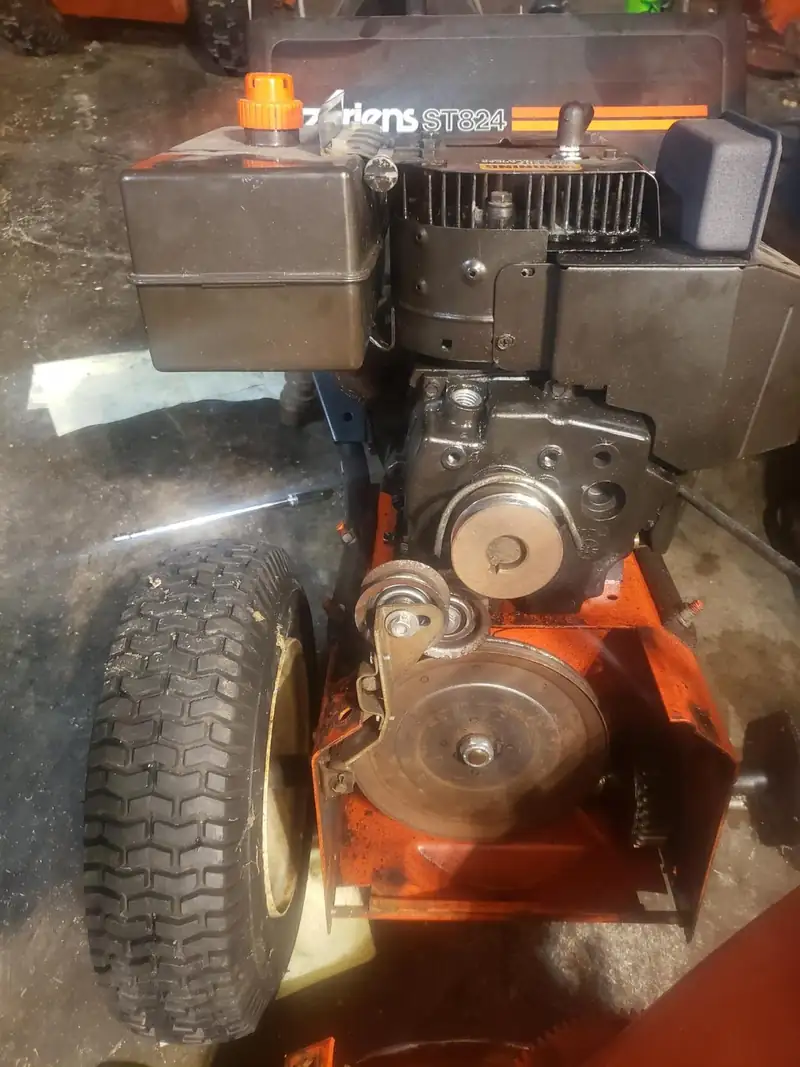 Ariens ST824 snowblower with the belt cover off.