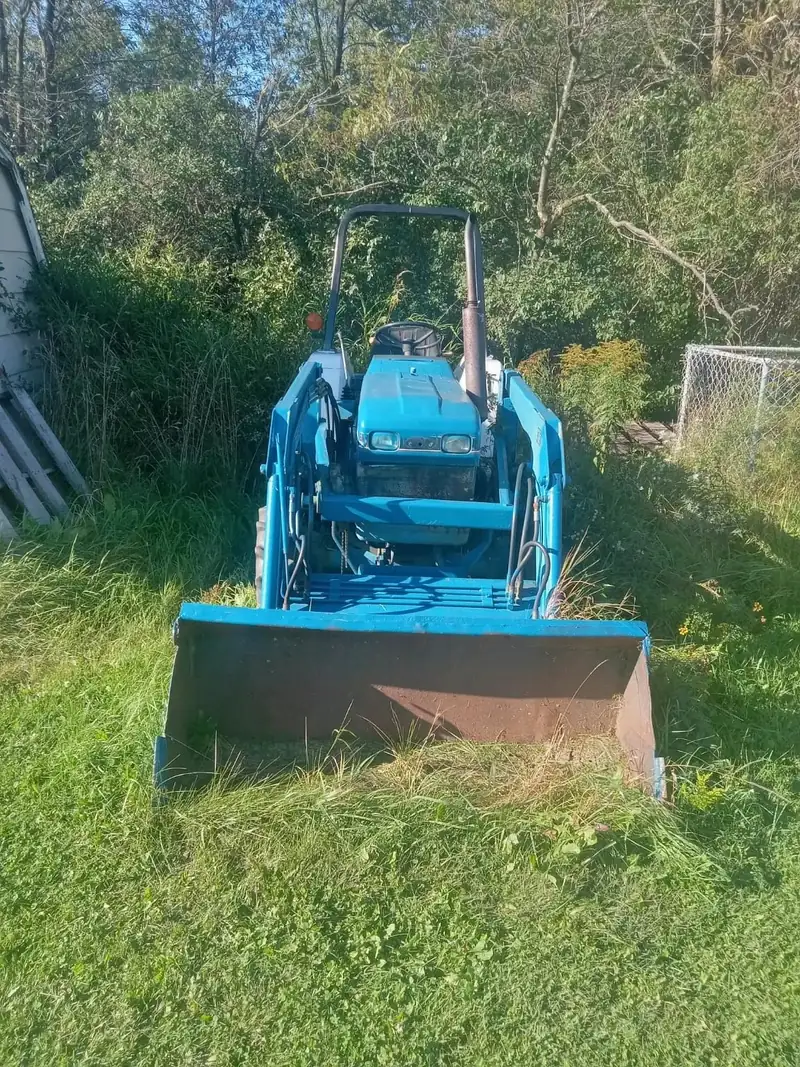A blue compact tractor with a front loader.